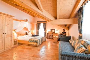 a hotel room with a bed and a couch at Albergo San Rocco in Peio