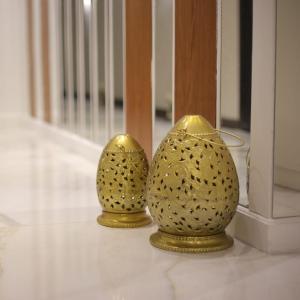 two gold vases are sitting on a floor at Apartment in Mohandesin (Families Only) in Cairo