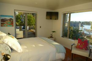 a bedroom with a large bed and a large window at Waterfront Bliss in Nelson