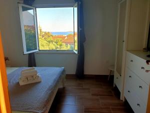 a small bedroom with a bed and a window at Apartments Ines in Orebić