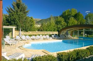 a swimming pool with lounge chairs and a swimming pool at Logis Hotel Restaurant Planes in Saillagouse