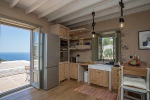 a kitchen with a refrigerator and a large window at Sunset & Ocean view Villa in Patmos