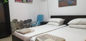 a room with two beds and a blue chair at Marina's Rooms in Larnaca