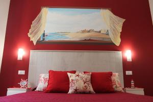 a bedroom with a bed with a painting above it at La casa del pescatore in Oliveri