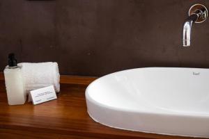 a bathroom sink with a soap dispenser and a towel at Windtown Lagoon Hotel in Langebaan