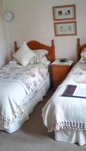 a bedroom with two beds and a dresser and a bed sidx sidx sidx sidx at Aydon House in Alnwick
