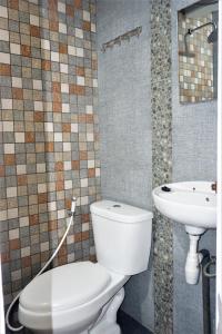 een badkamer met een toilet en een wastafel bij BRB Guesthouse in Banyuwangi