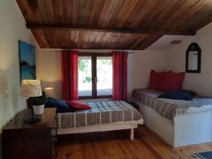 um quarto com uma cama e uma janela com cortinas vermelhas em Caseddu Di Poggiale em Figari