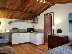 una cucina con armadi bianchi e soffitto in legno di Caseddu Di Poggiale a Figari