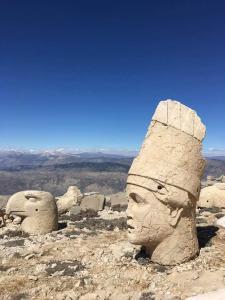 um grupo de estátuas de cabeça no topo de uma montanha em Nemrut Dağı Işik Pansi̇on em Karadut