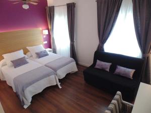 a hotel room with two beds and a couch at Hotel Llorca in Platja de l’Almadrava
