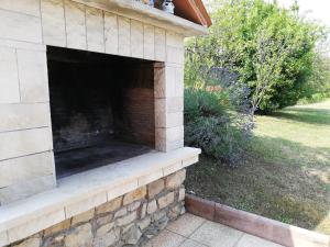 an outdoor brick fireplace in a house at Apartman Doli in Nedeščina