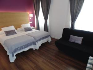a bedroom with a bed and a couch at Hotel Llorca in Platja de l’Almadrava