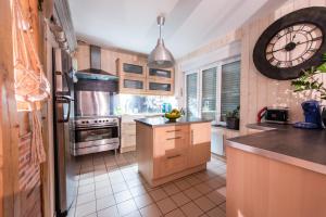 una cocina con un reloj grande en la pared en le clos du puits en Maslives