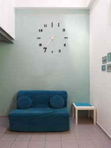 a blue couch in a room with a clock on the wall at Nel Blu in Limido Comasco