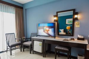 a room with a desk with chairs and a mirror at Aonang Buri Resort- SHA Extra Plus in Ao Nang Beach