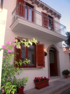 een huis met een balkon en bloemen in potten bij Suites de Mar in Santa Teresa Gallura