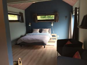 um quarto com uma cama, um sofá e 2 janelas em L'atelier em Durbuy