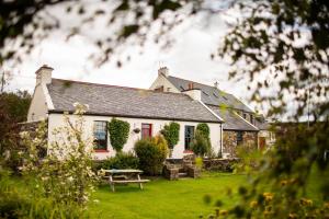 Biały dom ze stołem piknikowym przed nim w obiekcie Corcreggan Mill Lodge w mieście Dunfanaghy