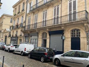 una fila de autos estacionados frente a un edificio en Gabylou, en Burdeos