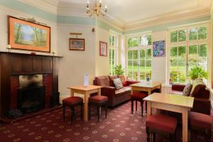 sala de estar con sofá y chimenea en Woodlands Hotel & Pine Lodges, en Grange-over-Sands