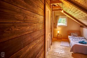 チスナにあるOsada Chyże Jewkiの木製の壁のベッドルーム1室(ベッド1台付)