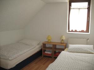 a attic bedroom with two beds and a window at Pension Hinz & Kunz in Weimar