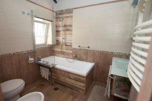 un bagno con vasca, WC e lavandino di Siriana open space a Castellammare di Stabia Altre 37 foto