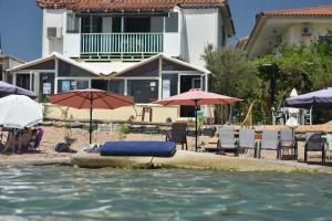 a pool with a blue raft in the water with umbrellas at Kassimiotis in Agios Andreas