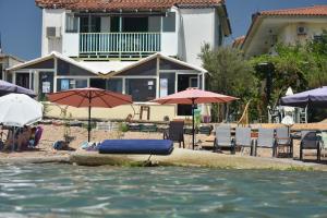 una piscina con una balsa azul en el agua con sombrillas en Kassimiotis, en Agios Andreas - Mesenia