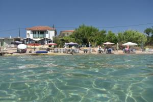 una playa con sillas y sombrillas en el agua en Kassimiotis, en Agios Andreas - Mesenia