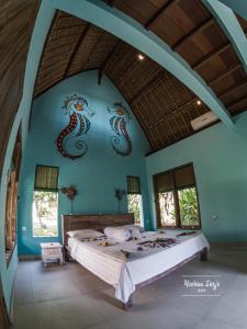 een slaapkamer met een bed met zeepaardjes aan de muur bij Kuda Laut Bungalows & Diving in Pemuteran