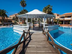 a wooden bridge over a swimming pool with a gazebo at Tenerife Royal Gardens - Las Vistas TRG - Viviendas Vacacionales in Playa de las Americas