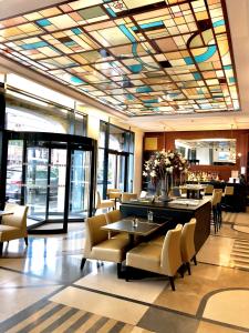 a lobby with a restaurant with tables and chairs at Hotel Art Deco Euralille in Lille