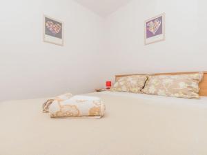 a white bed with two pillows and a purse on it at Apartment F-1 Klimno in Klimno +16 photos