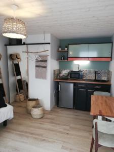 a kitchen with black cabinets and a wooden floor at COUP DE COEUR Studio in Rivedoux-Plage