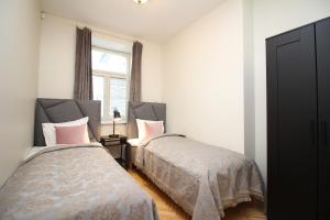 een slaapkamer met 2 bedden en een raam bij Tallinn City Apartments 4 bedroom with sauna and 2 bathroom in Tallinn