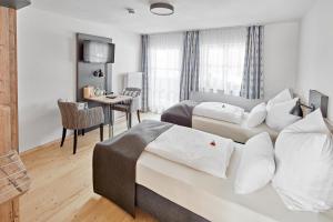 ein Hotelzimmer mit einem Bett, einem Schreibtisch und einem Zimmer in der Unterkunft Hotel Garni Alte Säge Ruhpolding in Ruhpolding