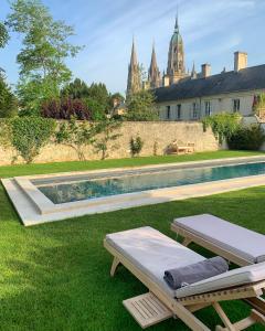 a swimming pool in the yard of a house at Le Tardif, Noble Guesthouse in Bayeux