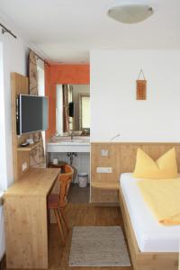 a bedroom with a bed and a desk with a television at Gasthaus Storchen in Waldshut-Tiengen