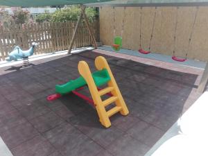 a playground with a slide and a swing at Camping Victoria in Capaccio-Paestum