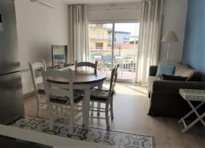 cocina y sala de estar con mesa y sillas en Mont-Roig Apartment, en Cambrils