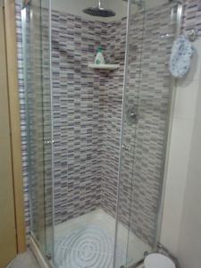 a shower with a glass door in a bathroom at Appartamento in Residenza Punta di Sabaudia - seminterrato in Sabaudia