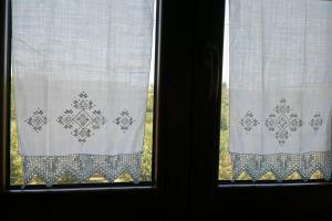 dos ventanas con cortinas blancas con estampados. en Casale dei Lamponi a "le Moline" vita in fattoria, en Vetralla