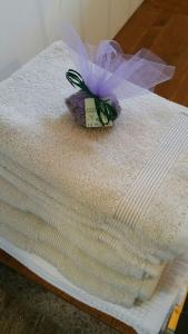 Una toalla blanca con una flor morada encima. en Casale dei Lamponi a "le Moline" vita in fattoria, en Vetralla