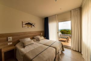 A bed or beds in a room at Hotel Tamariu