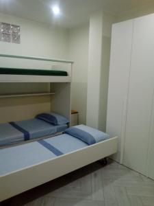 2 letti a castello in una piccola camera con cuscini blu di Appartamento in Residenza Punta di Sabaudia - seminterrato a Sabaudia