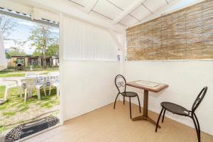 einen Tisch und Stühle in einem Zimmer mit Fenster in der Unterkunft Camp Mali bungalow in Baška