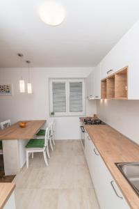 a kitchen with white cabinets and a wooden counter top at Apartment Bambi in Mali Lošinj