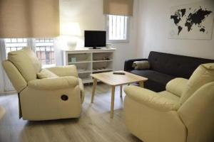 sala de estar con 2 sillas, sofá y mesa en Apartamento Blanes, en Granada